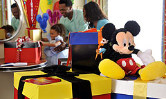 A girl dressed like a princess enjoys in-room decorations with her parents.