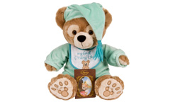 A teddy bear wears a sea green night cap with blue tassel and pajamas, holding a card between his foot paws.
